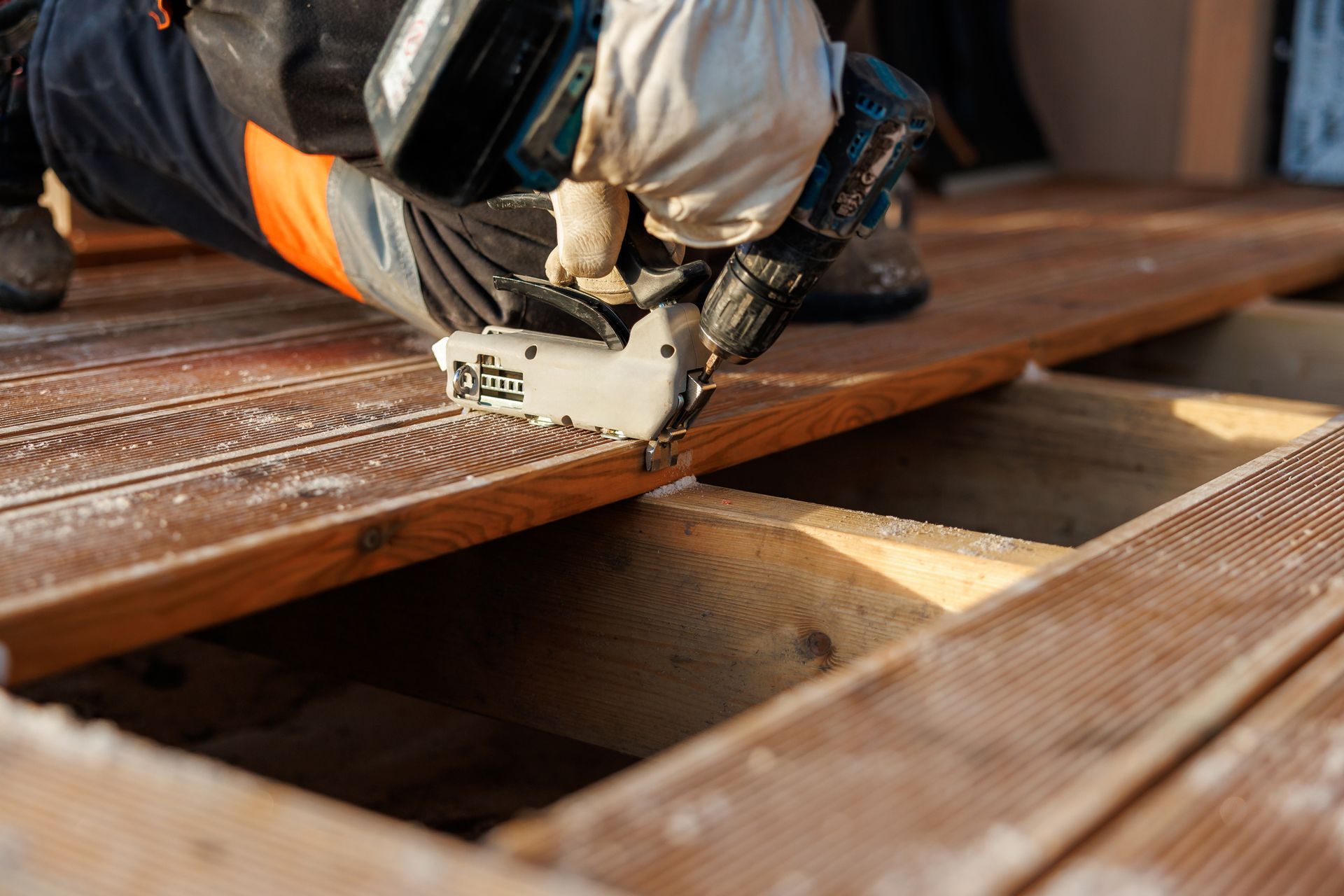 Wooden deck boards secured with black straps over a concrete surface