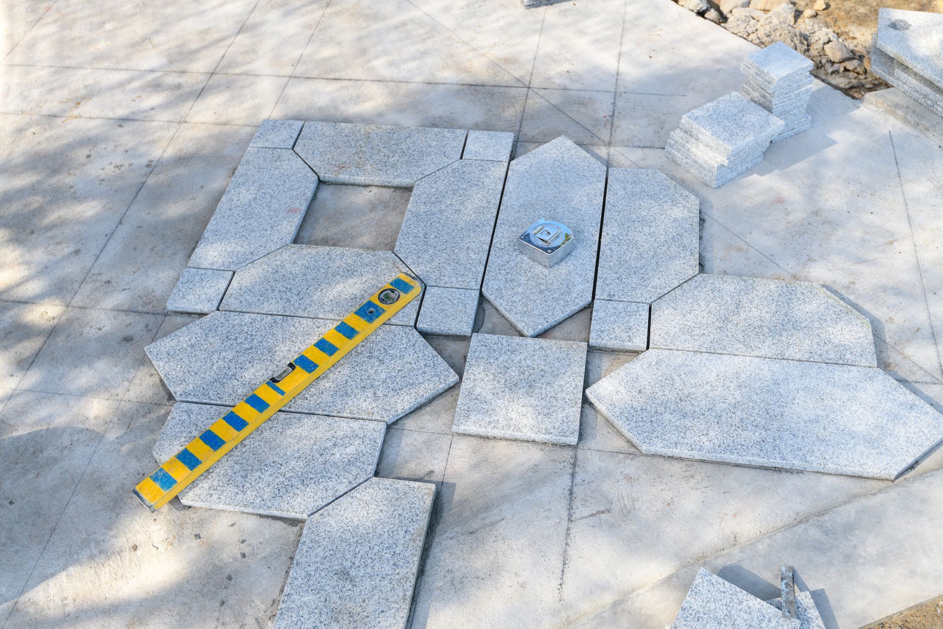 A yellow and blue tape measure is laying on a tiled floor.