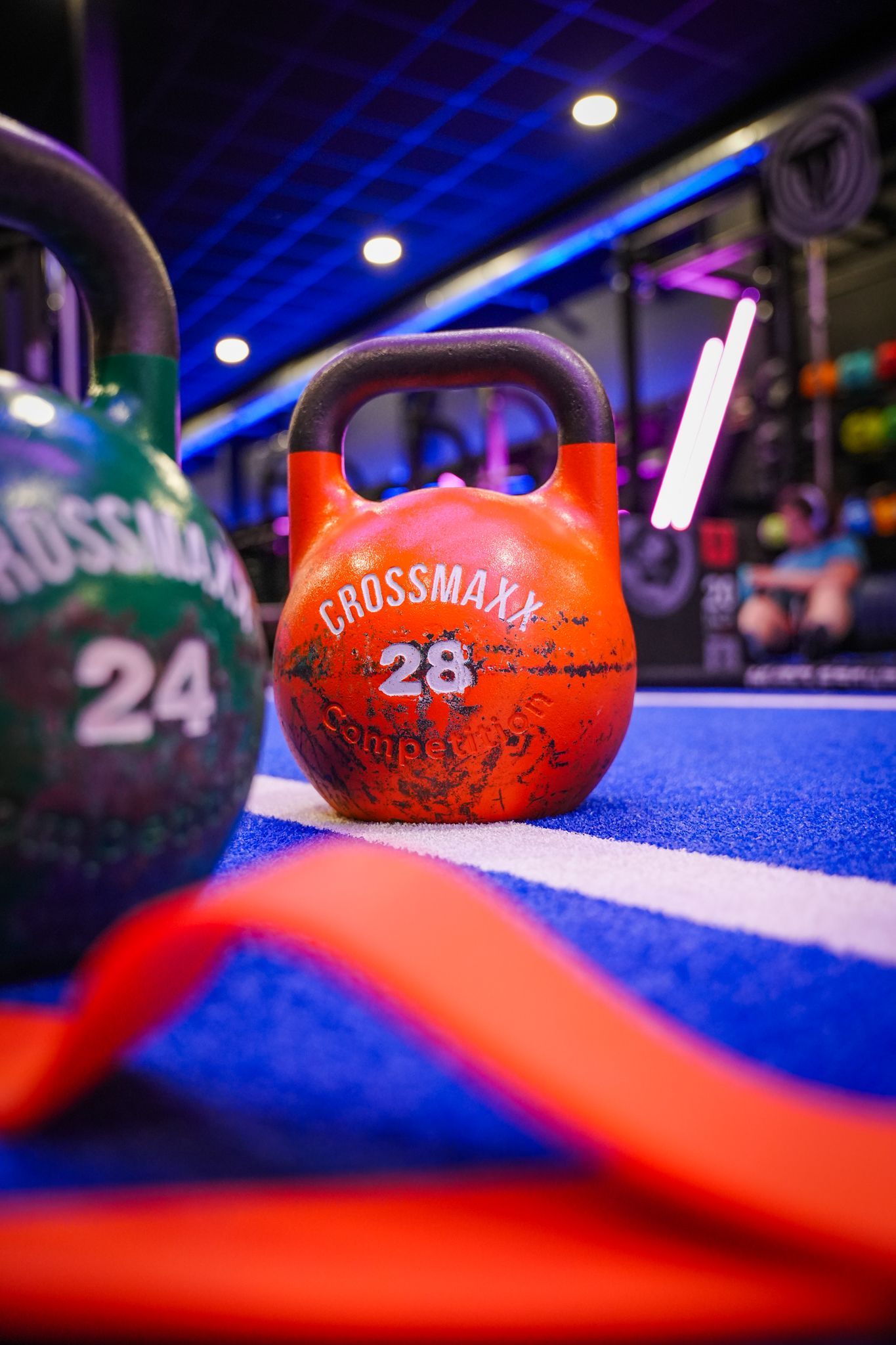Een sportschool met een neonreclame waarop staat: 'Tijd om te trainen'.