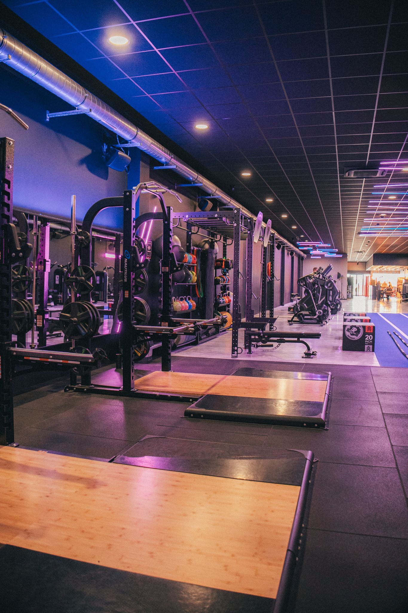 Een gymzaal met veel apparatuur en een blauwe vloer.