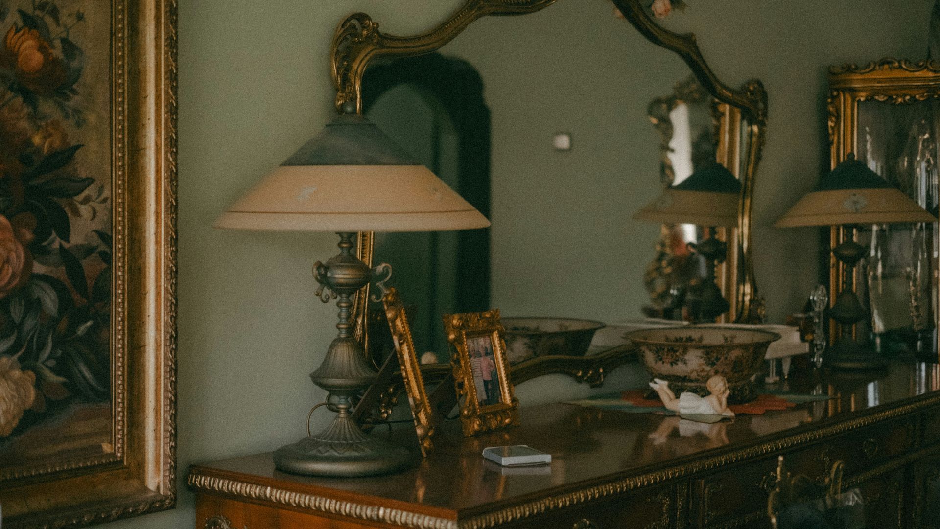 A lamp is on a table in front of a mirror