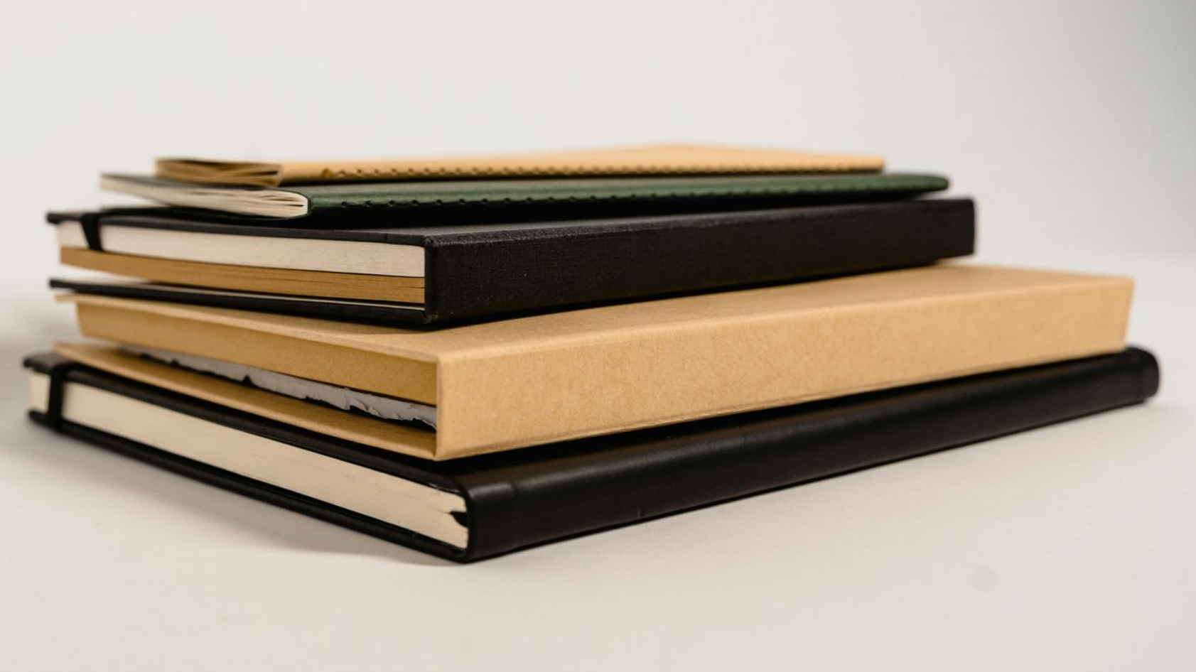 A pile of blank note books that represent ledgers containing detailed records of estate items