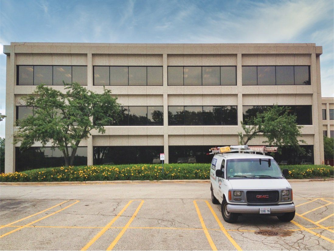 Empty asphalt parking lot in front of an office building after masonry cleaning