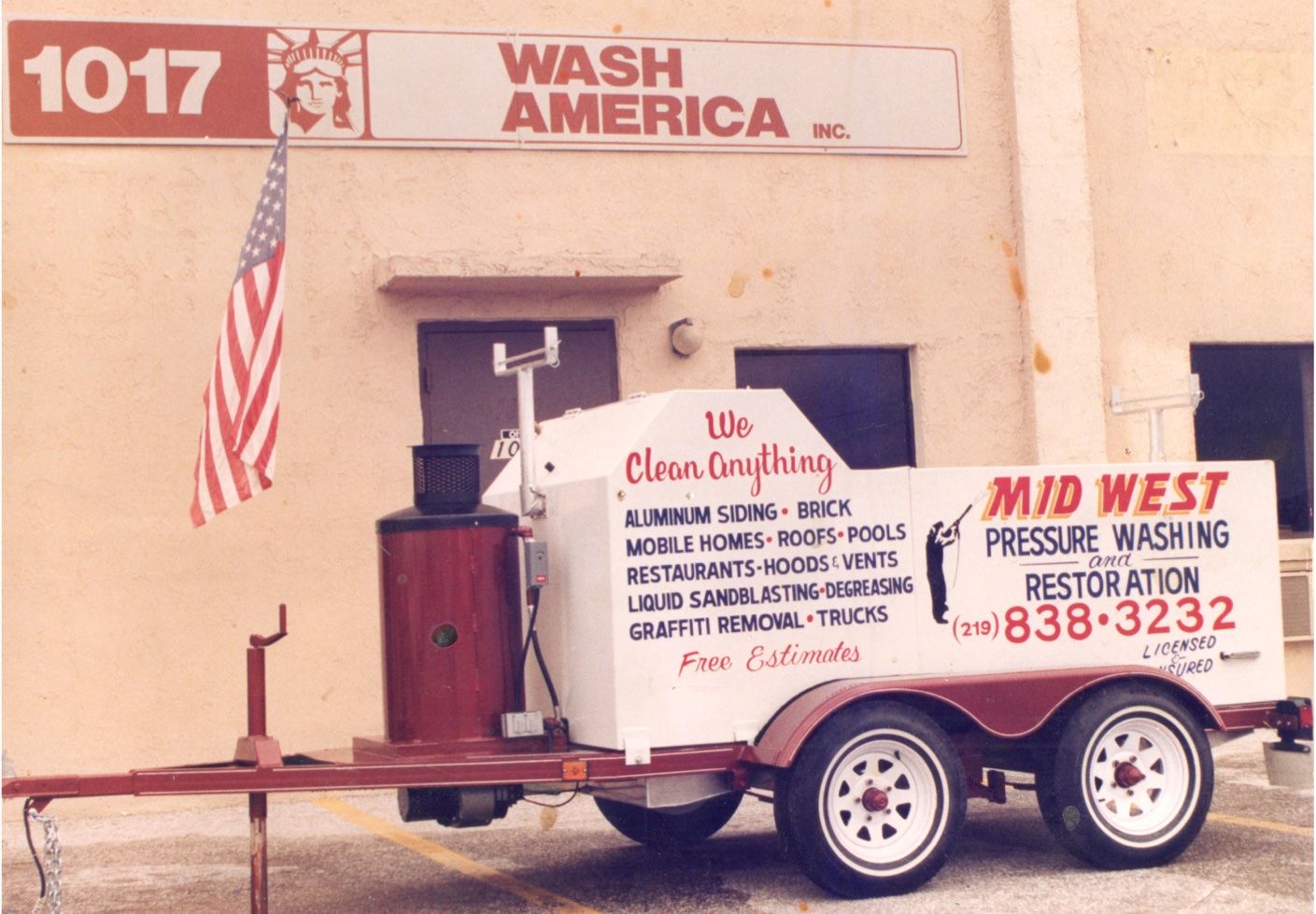 A trailer with a pressure washer in front of a Wash America building.