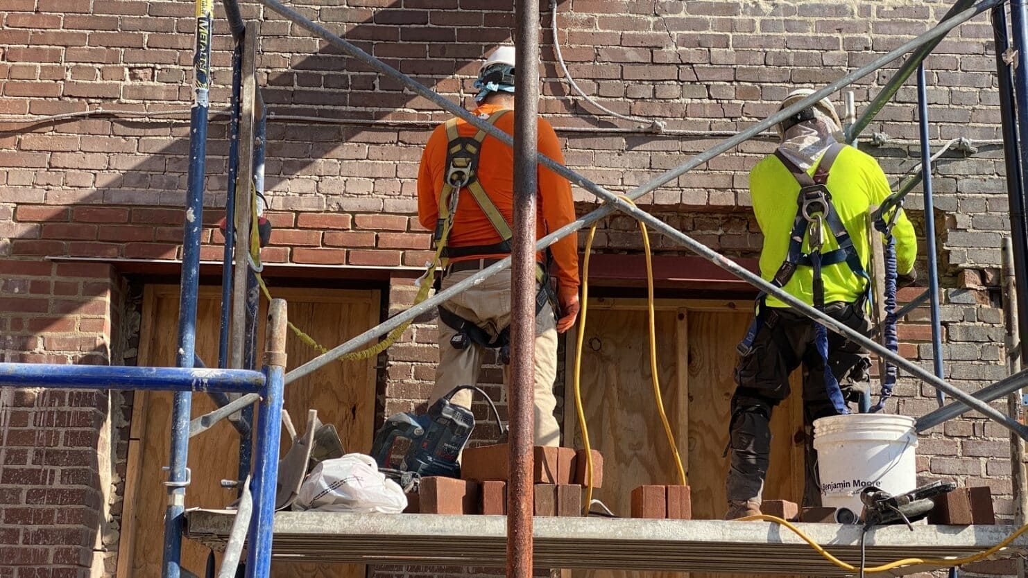 RestoreWorks masons performing lintel replacement and brick repair on a historic masonry facade to stabilize structure and restore long-term integrity.