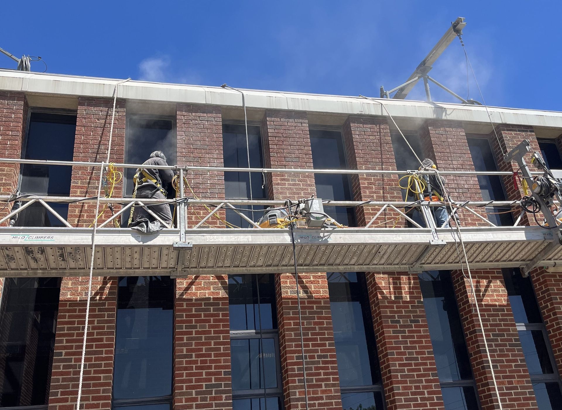 RestoreWorks crew on swing stage performing tuckpointing on brick façade at Evanston High School during spring break.