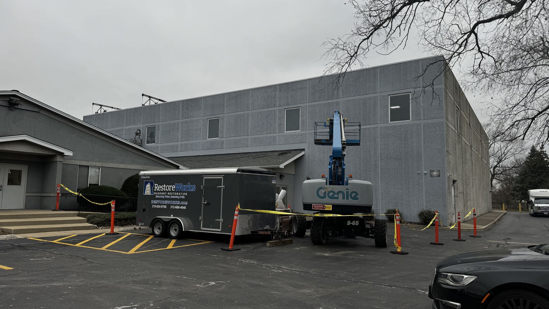 RestoreWorks masonry restoration crew performing exterior envelope repairs at Calvary Academy in South Holland Illinois using lift access to address joint and sealant failures.