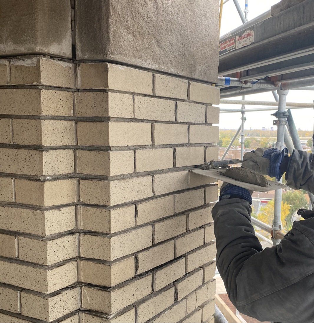 Commercial tuckpointing contractor repairing mortar joints on a brick façade in Chicago.