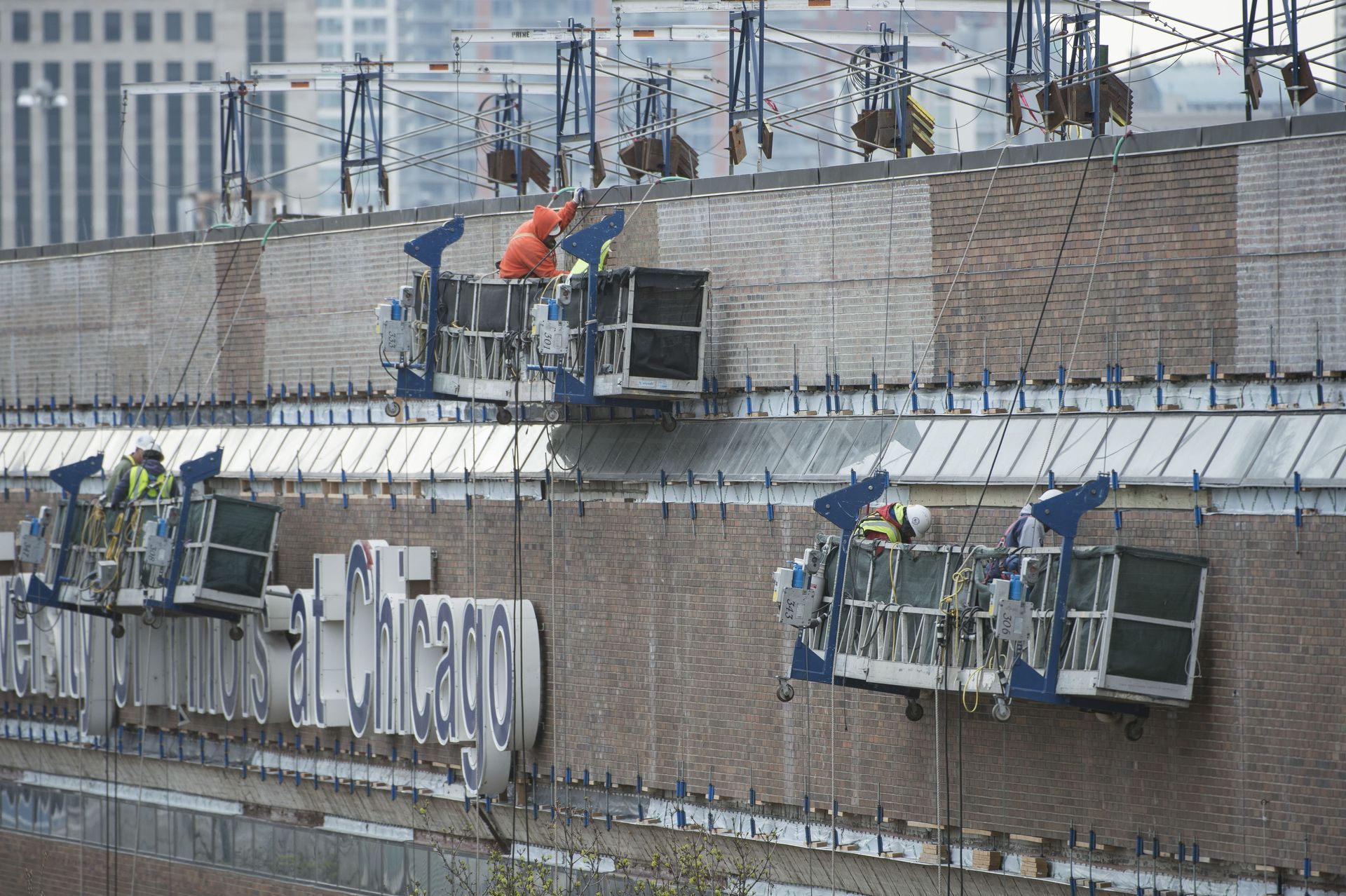 RestoreWorks crews performing masonry restoration on suspended scaffolds at the University of Illinois Chicago campus.