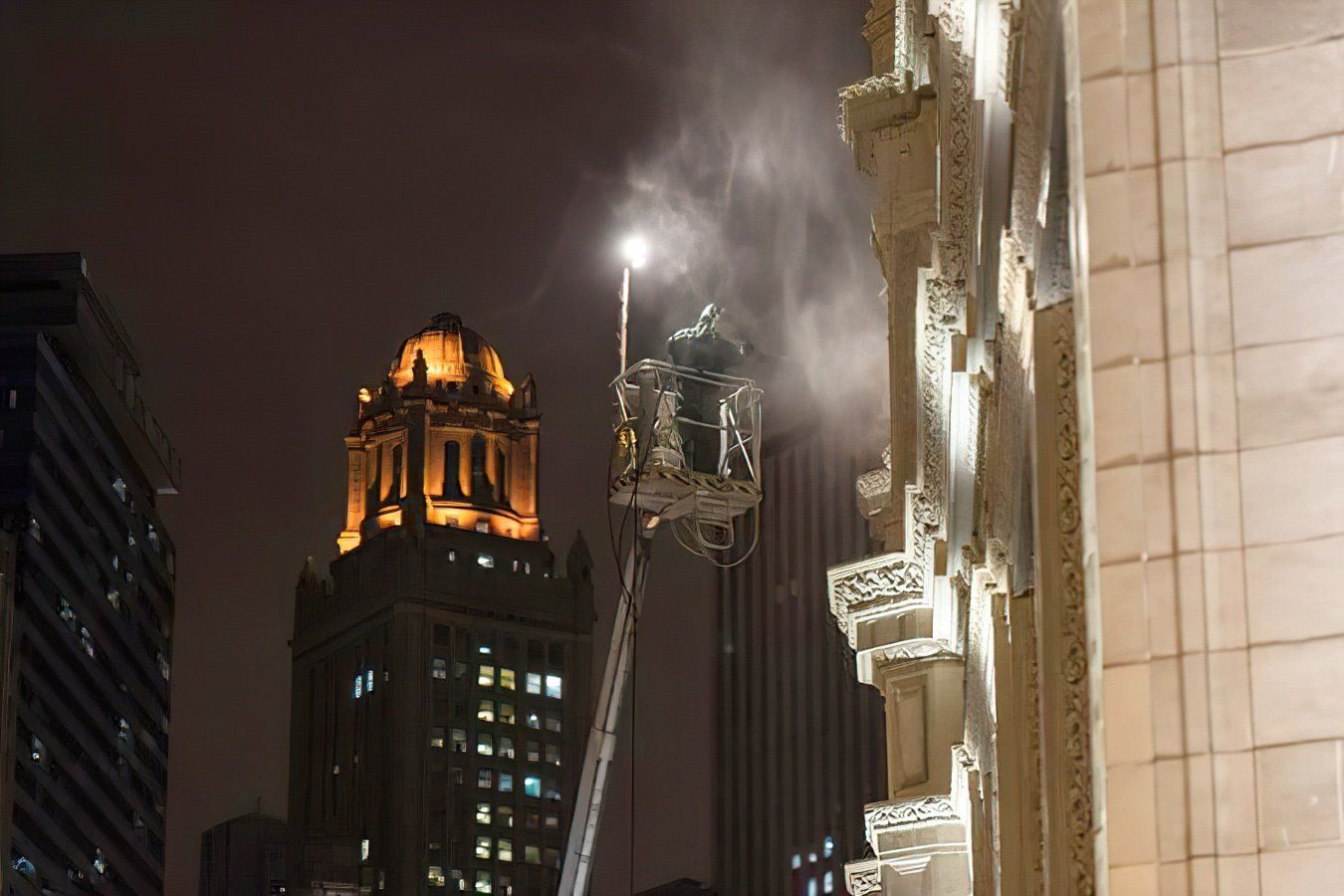 A man is cleaning the Wrigley building at night