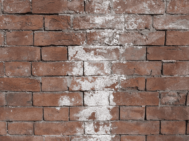 Red brick wall with white paint stains and weathered mortar lines