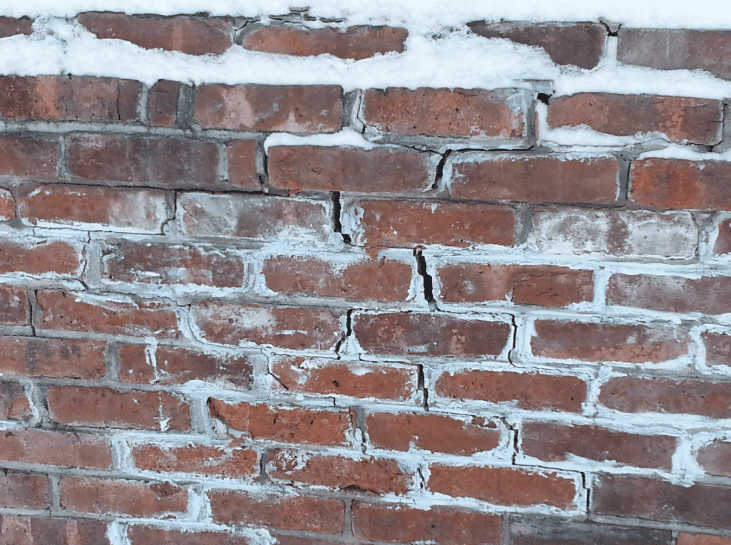 Red brick wall with weathered white mortar and chipped paint