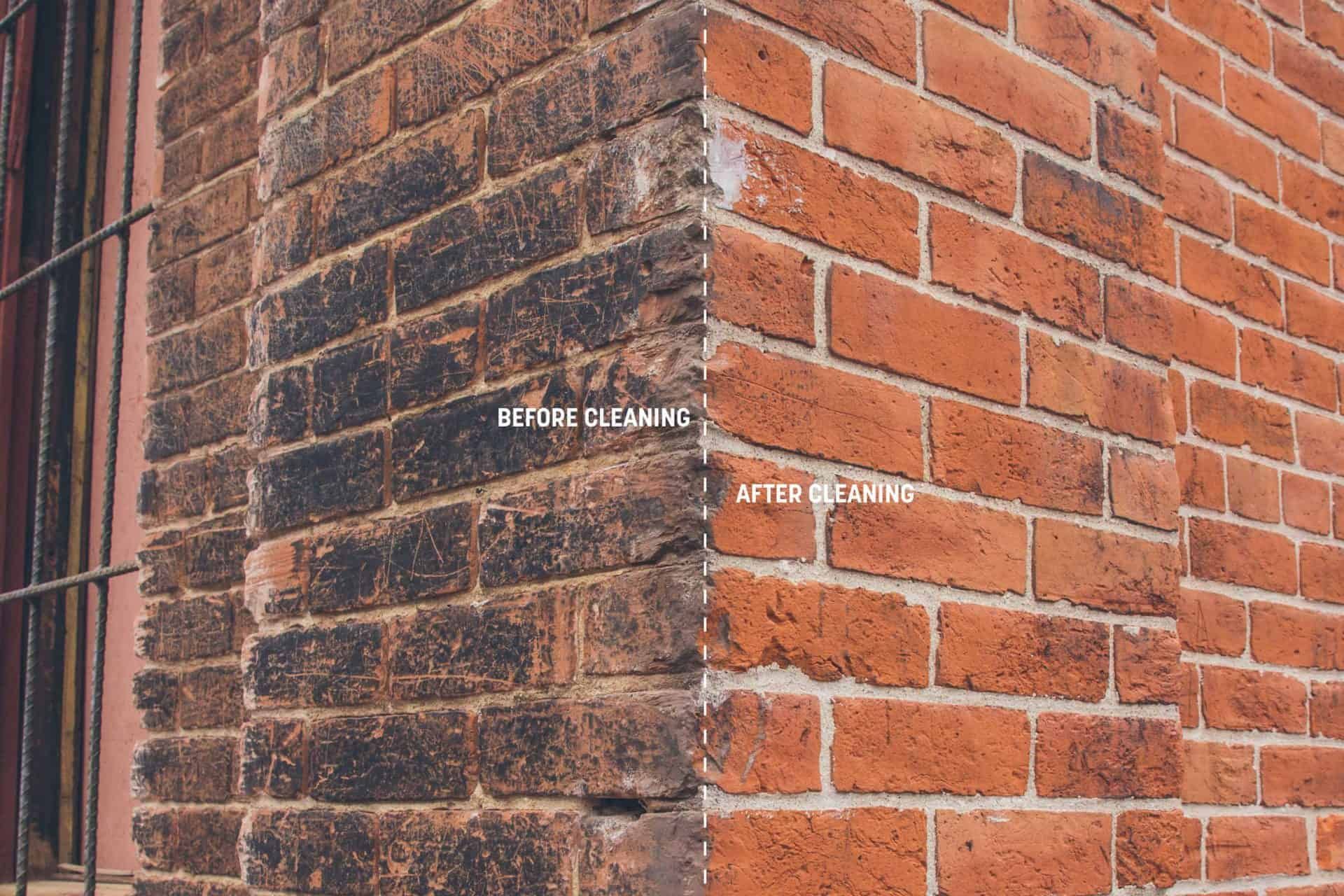 Close-up of a brick corner with blackened soot on one side and clean red brick on the other.