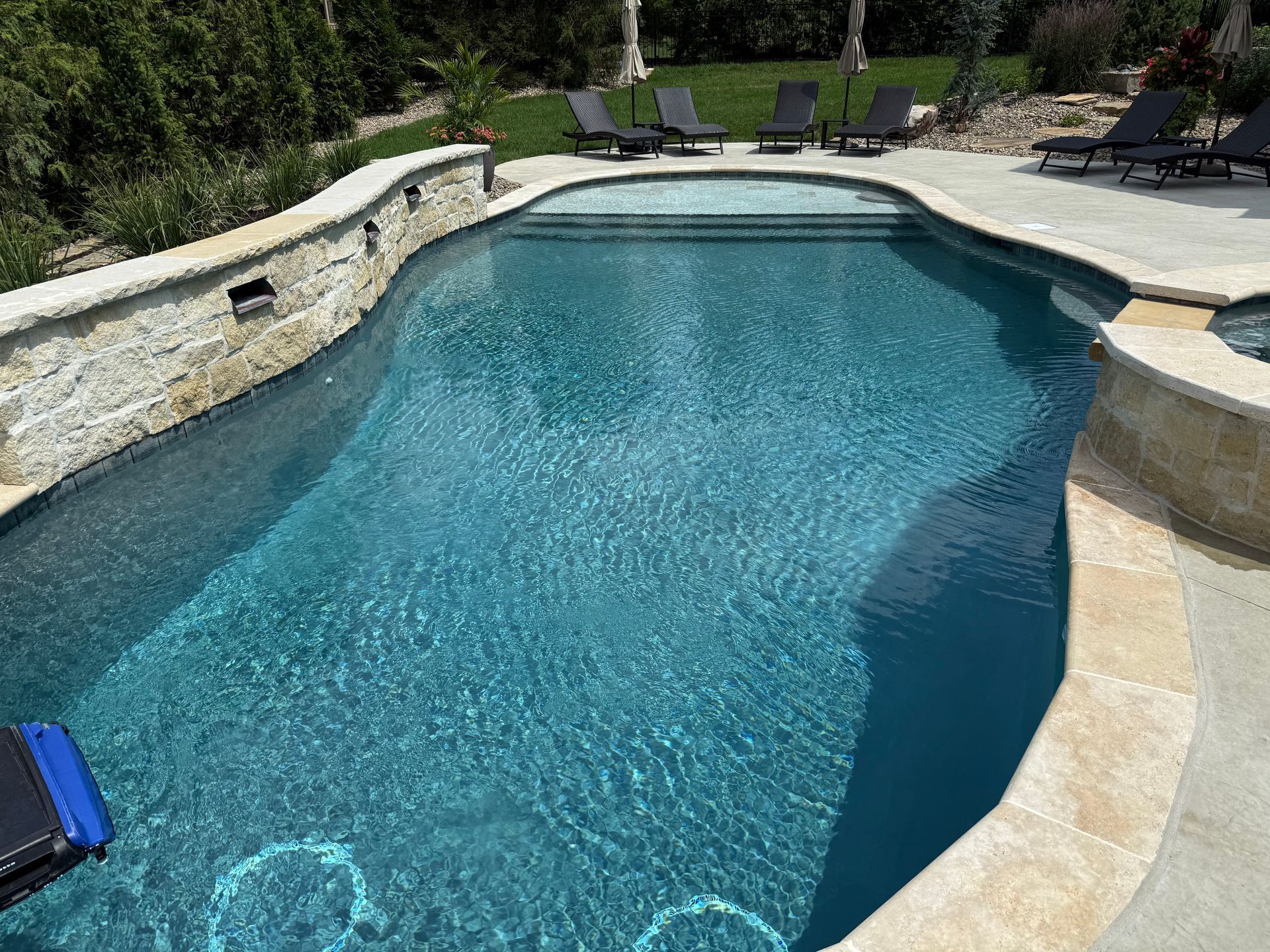 Custom gunite pool with spillover spa and water feature wall in Overland Park KS