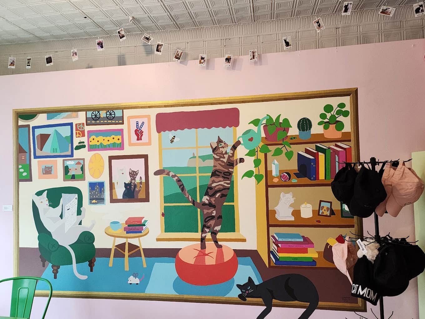 Colorful illustrated room mural with plants, window, shelves, and hanging clothes on a pink wall