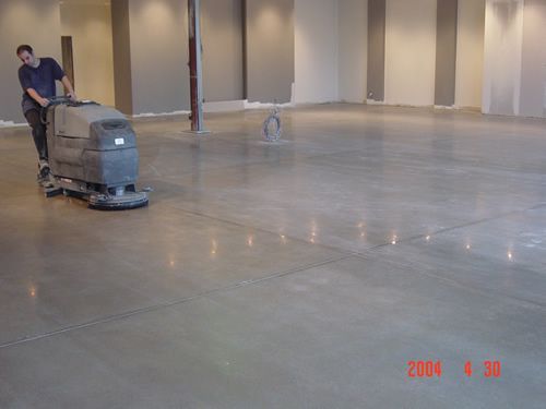 A man is using a machine to clean a concrete floor.
