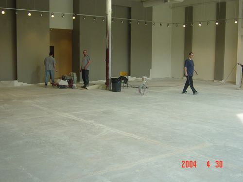 A group of men are standing in an empty room with a date stamp of 2004