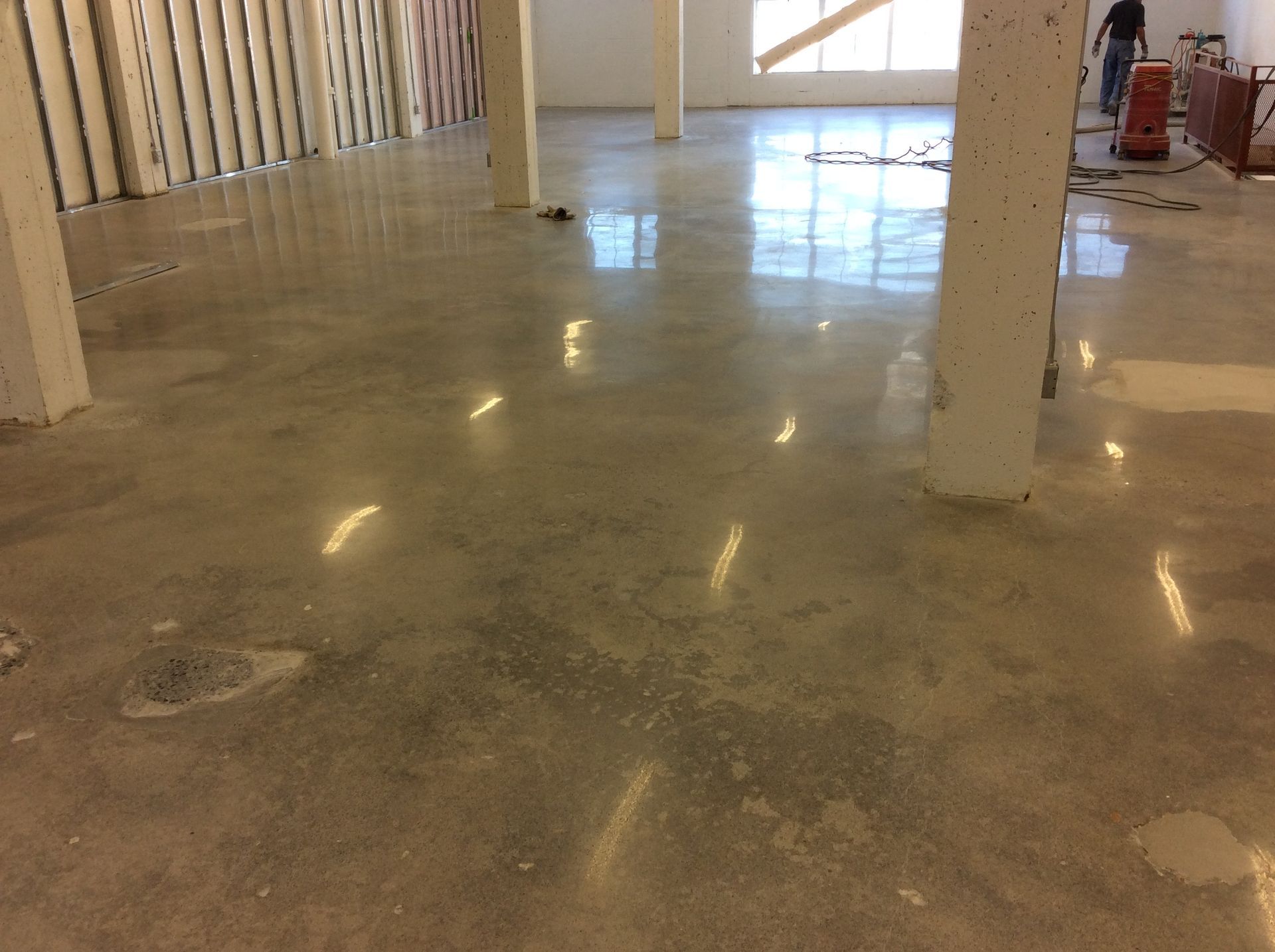 Une grande pièce avec un sol en béton et des piliers