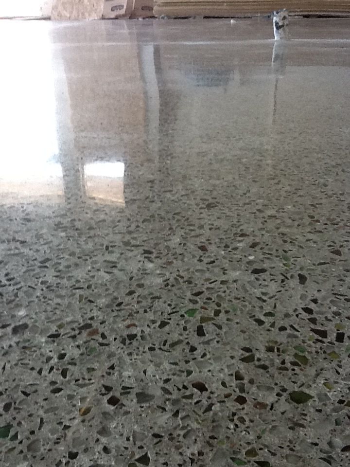 Un gros plan d'un sol en béton brillant avec beaucoup de petits rochers dessus.