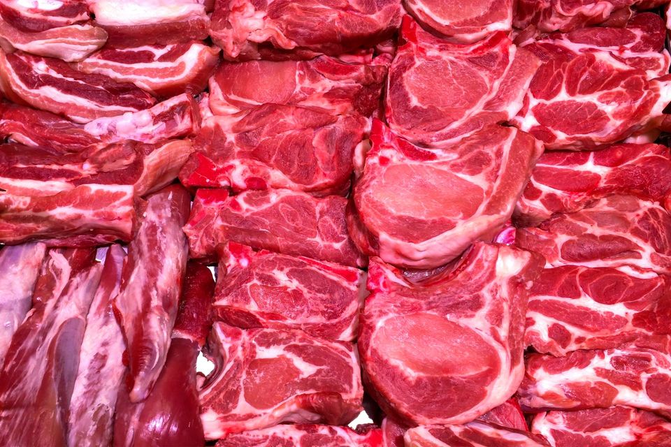 Assortimento di tagli di carne rossa cruda esposti in un banco da mercato.