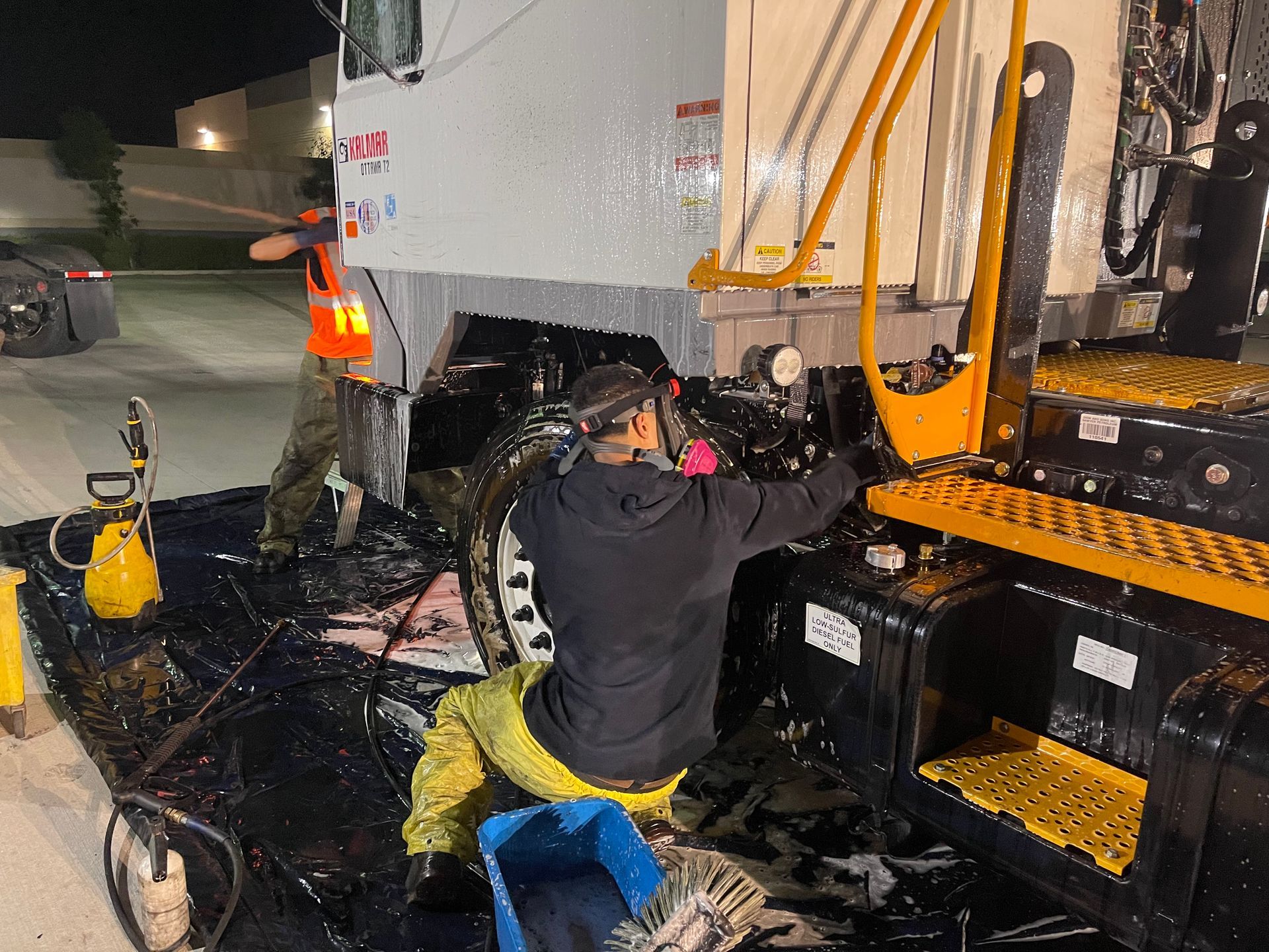 A man is working on a truck with the number 11 on it