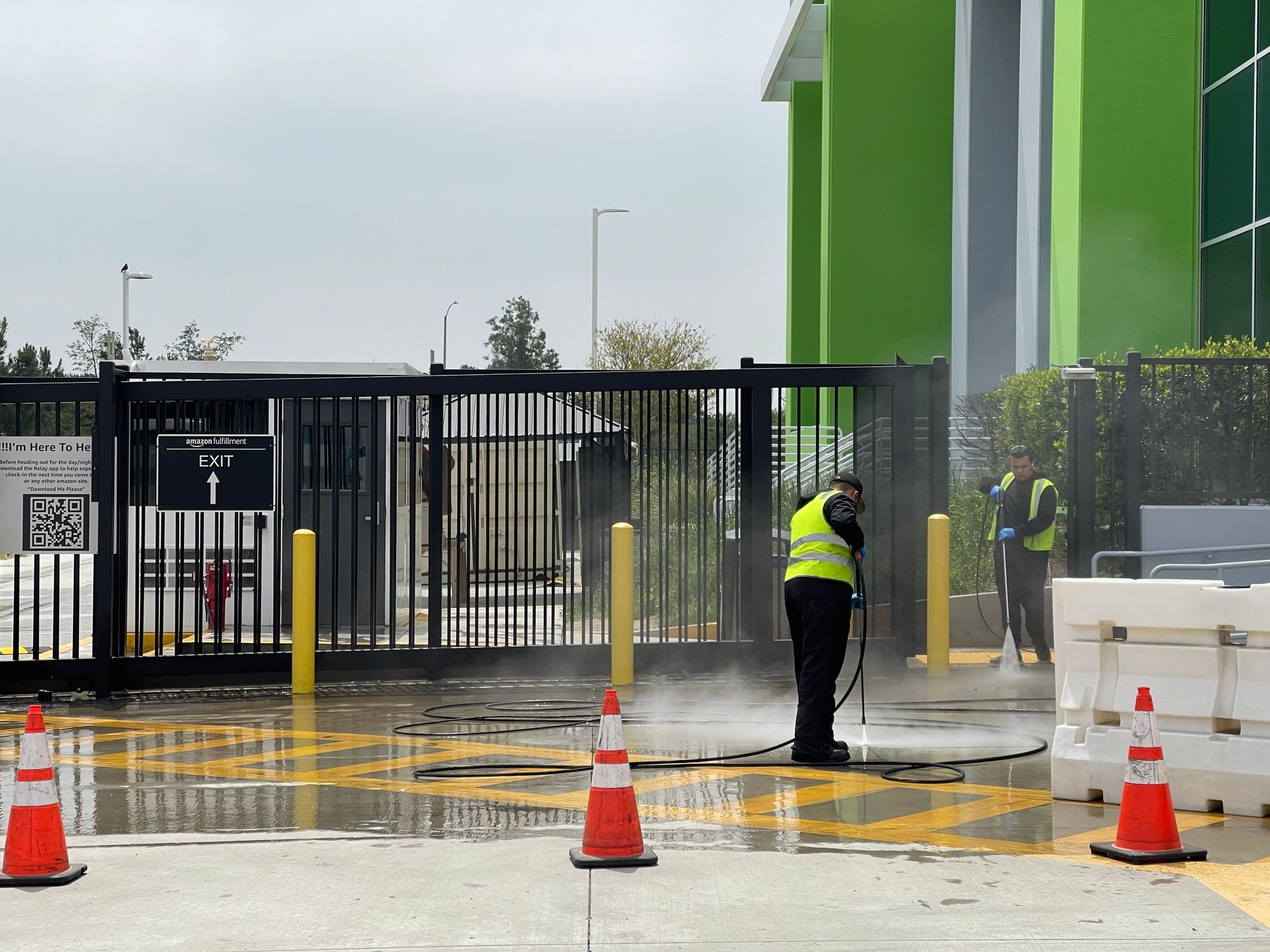 A man is cleaning a gate with a high pressure washer