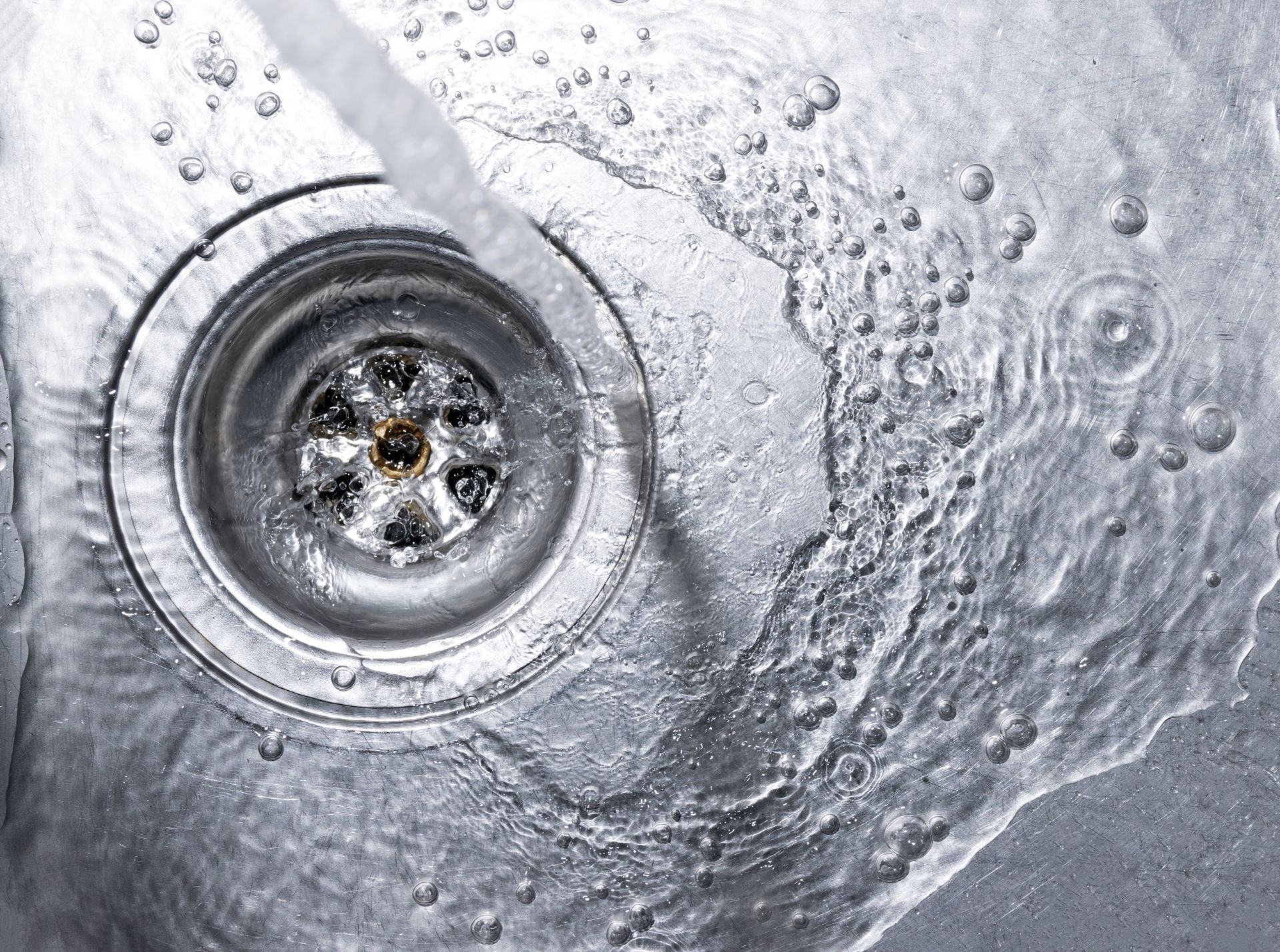 Un gros plan d'un évier avec de l'eau qui coule dans le drain.