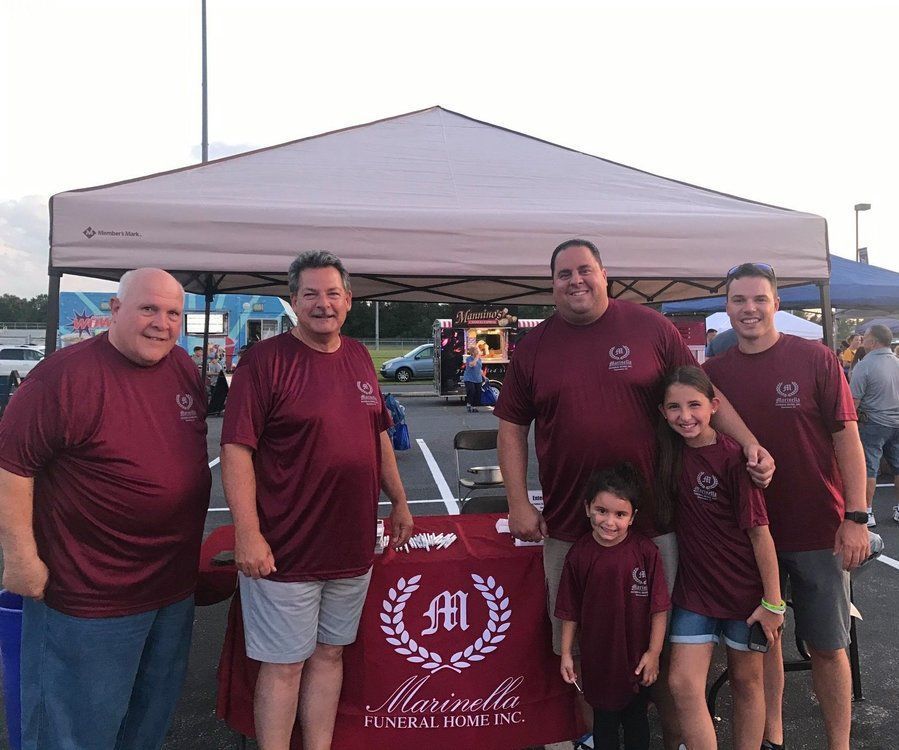 A group of people are posing for a picture in front of a tent.