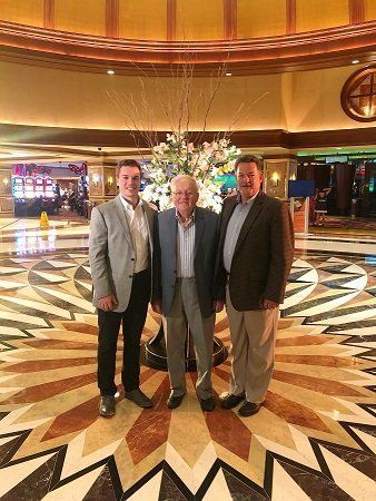Three men are posing for a picture in a hotel lobby.