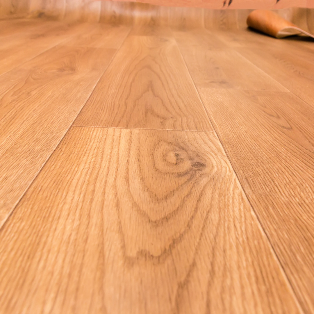 A close up of a wooden floor with a person standing on it.