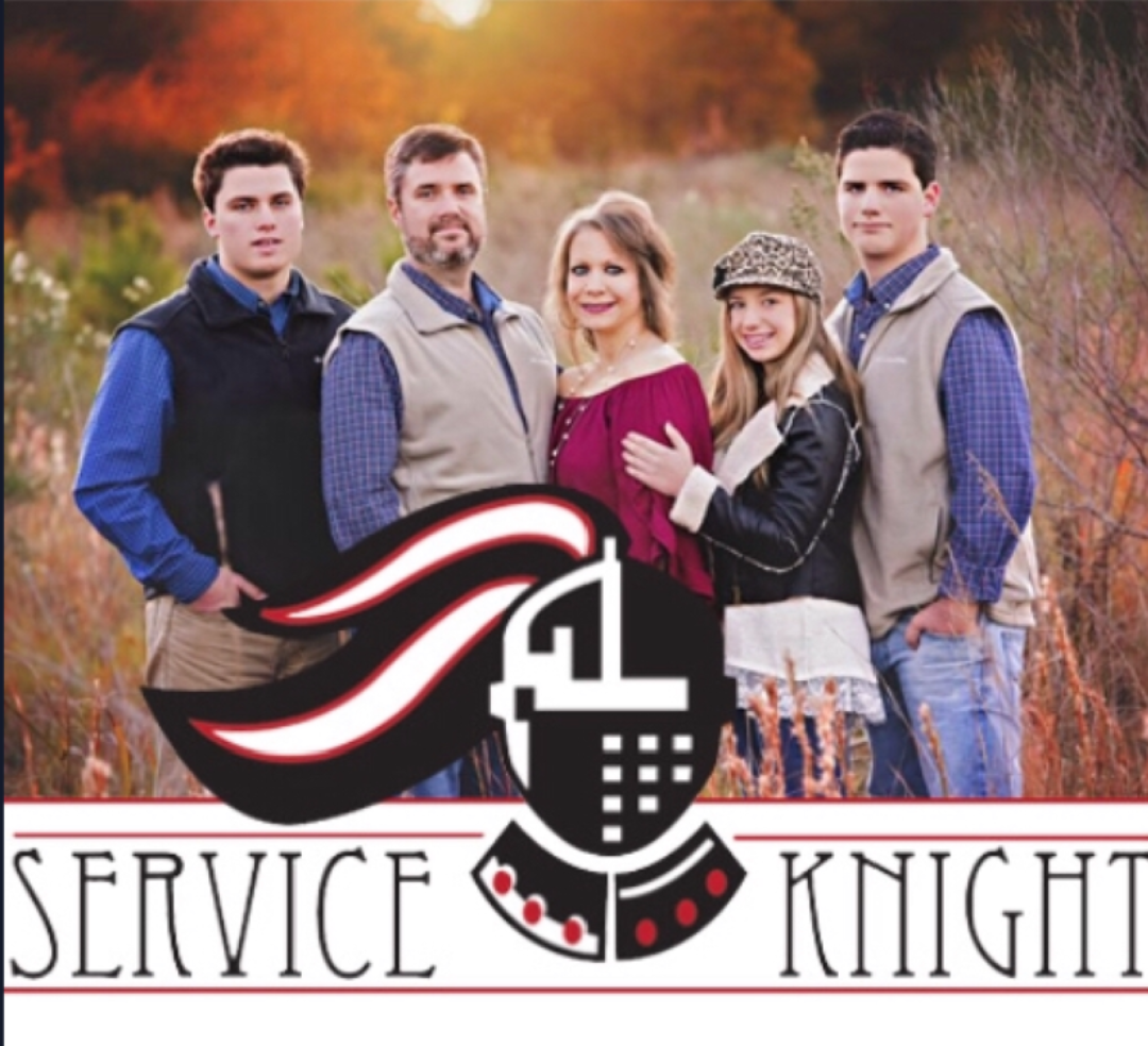 A group of people standing in a field with a service knight logo
