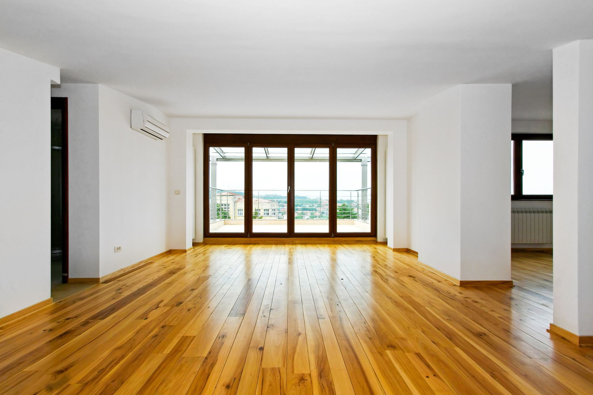 A room with a large window and wood for a Wood Floor Installation