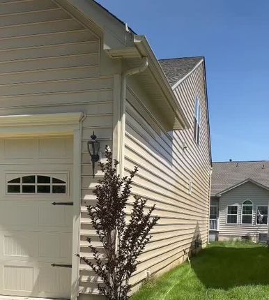 Garage and exterior siding from a Gcapital soft-washing project video.