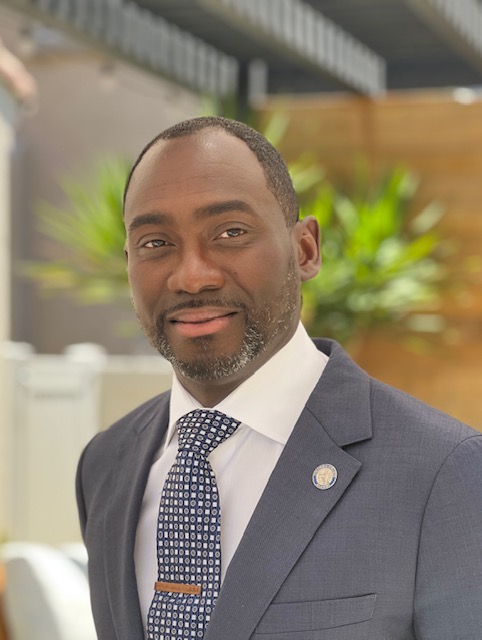 A man in a suit and tie is smiling for the camera.