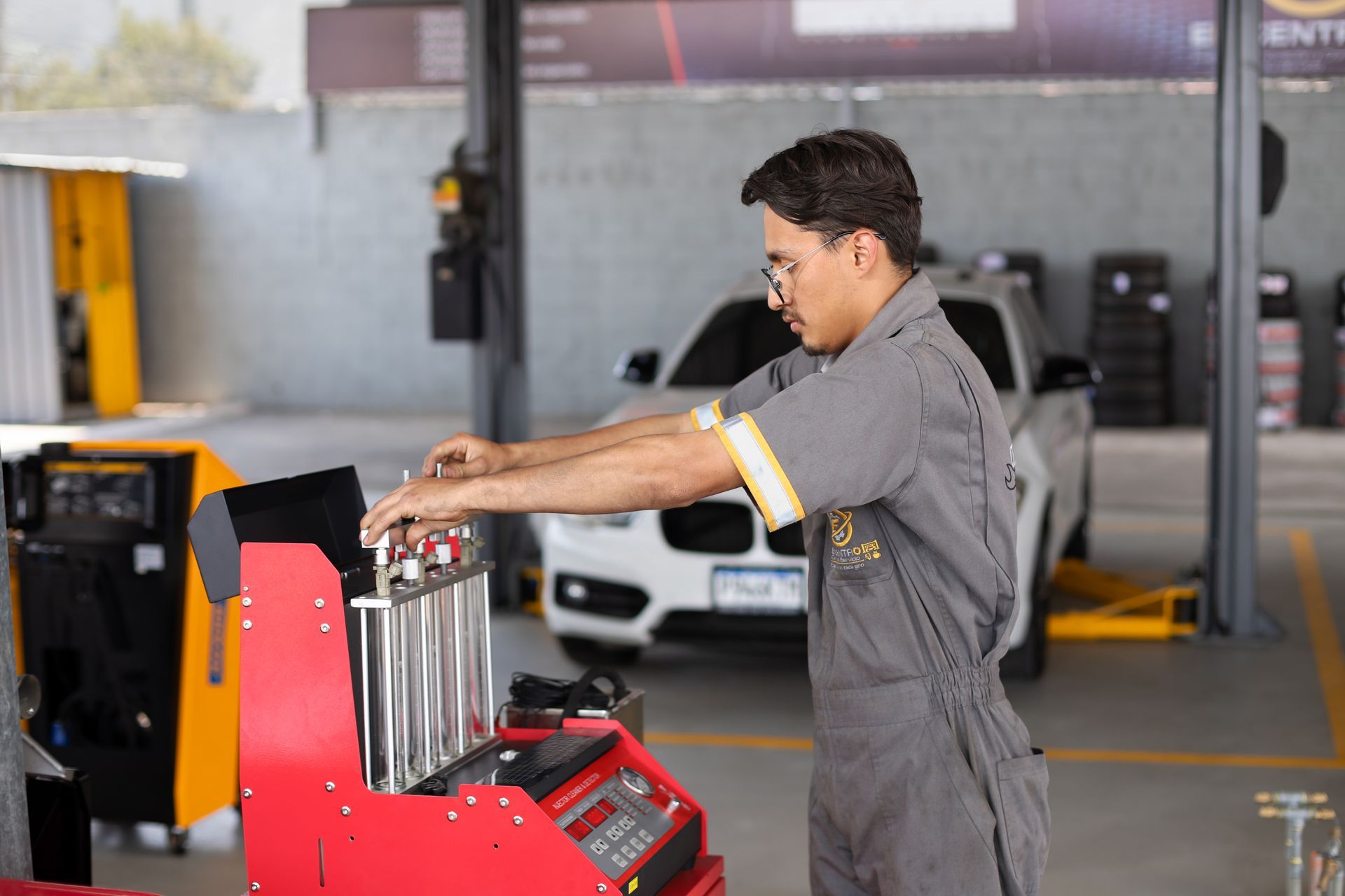 Mecánico trabajando en el motor de un coche con el capó abierto en un taller mecánico.