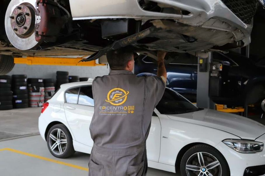 Mecánico aprieta un disco de freno de un coche con una llave inglesa en un taller.