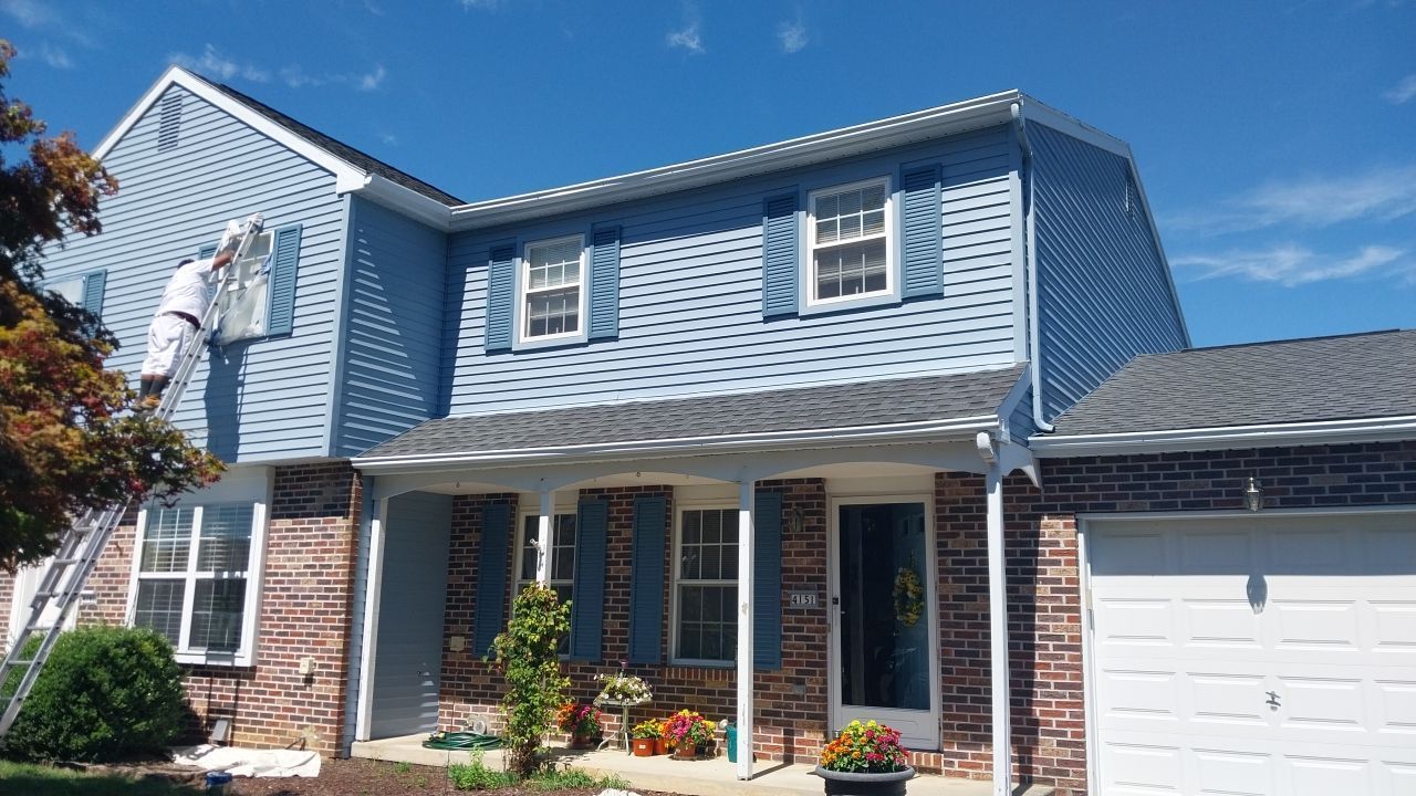 Second-story exterior freshly painted with blue siding and matching blue shutters – after exterior painting project in Emmaus, PA by Liberty & Freedom Painting.