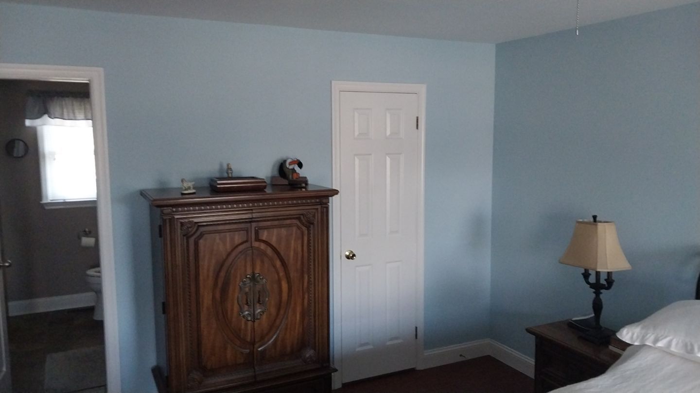 Master bedroom with light blue walls and white baseboards – after interior painting in Hatfield, PA by Liberty & Freedom Painting.
