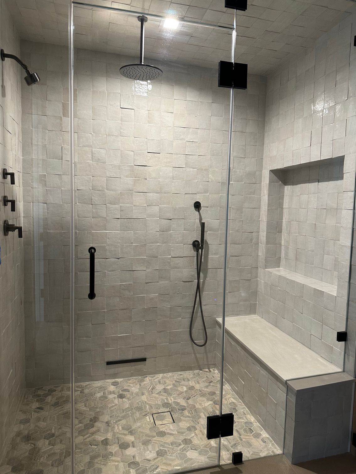 Close-up of patterned floor with green and tan floral shapes, reflecting sunlight and a window view.