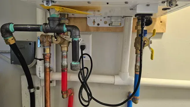 Close-up of chrome plumbing pipes against cream-colored tile. Plumbing Services in Northville