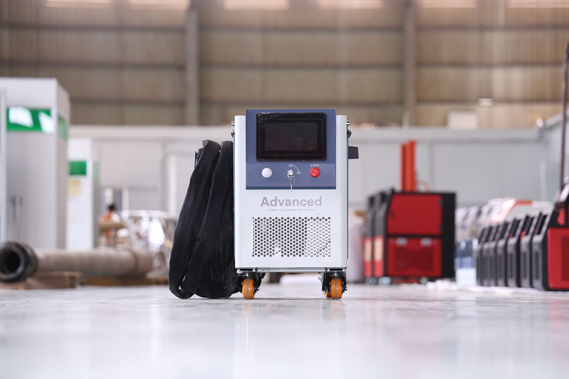 A medical machine on wheels in a warehouse setting, with a screen and attached black tubing.