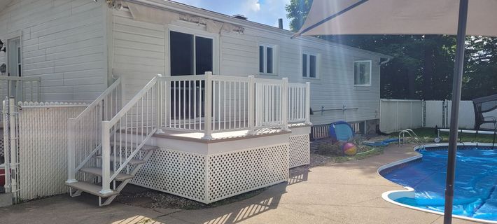 Terrasse arrière avec escalier blanc à côté d'une petite piscine bleue et d'un extérieur de maison
