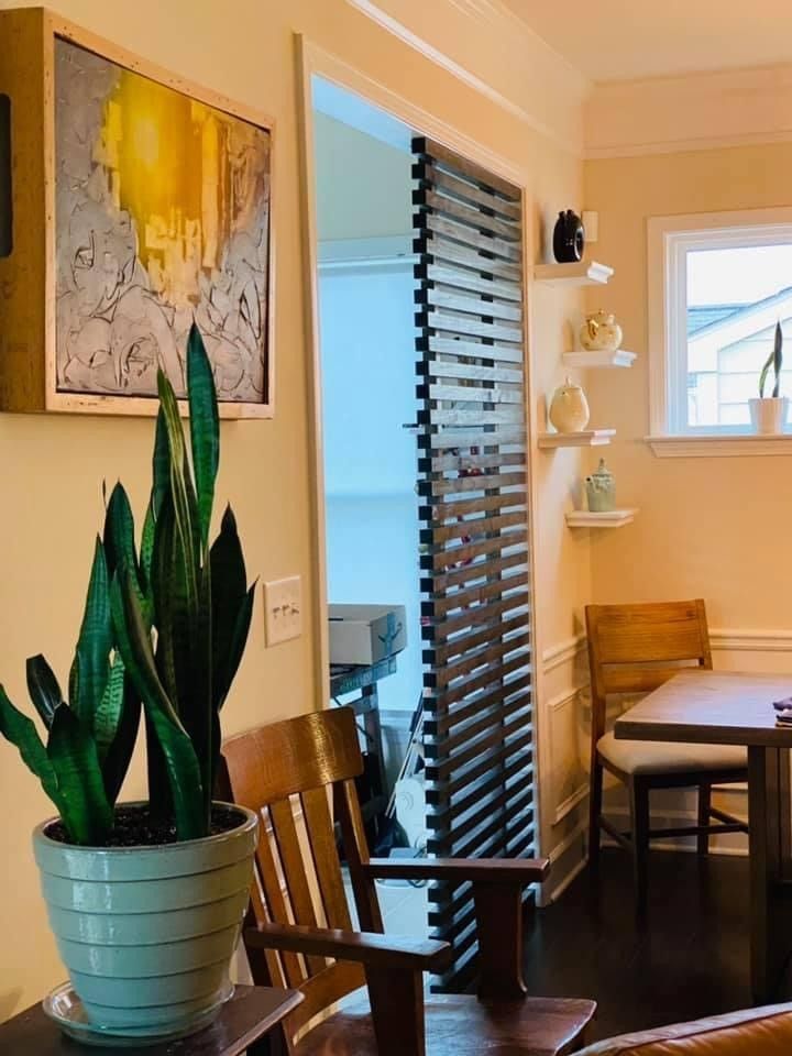 Bright dining nook with wooden chairs, potted plant, wall art, and a round table by a small window | Decatur, IL