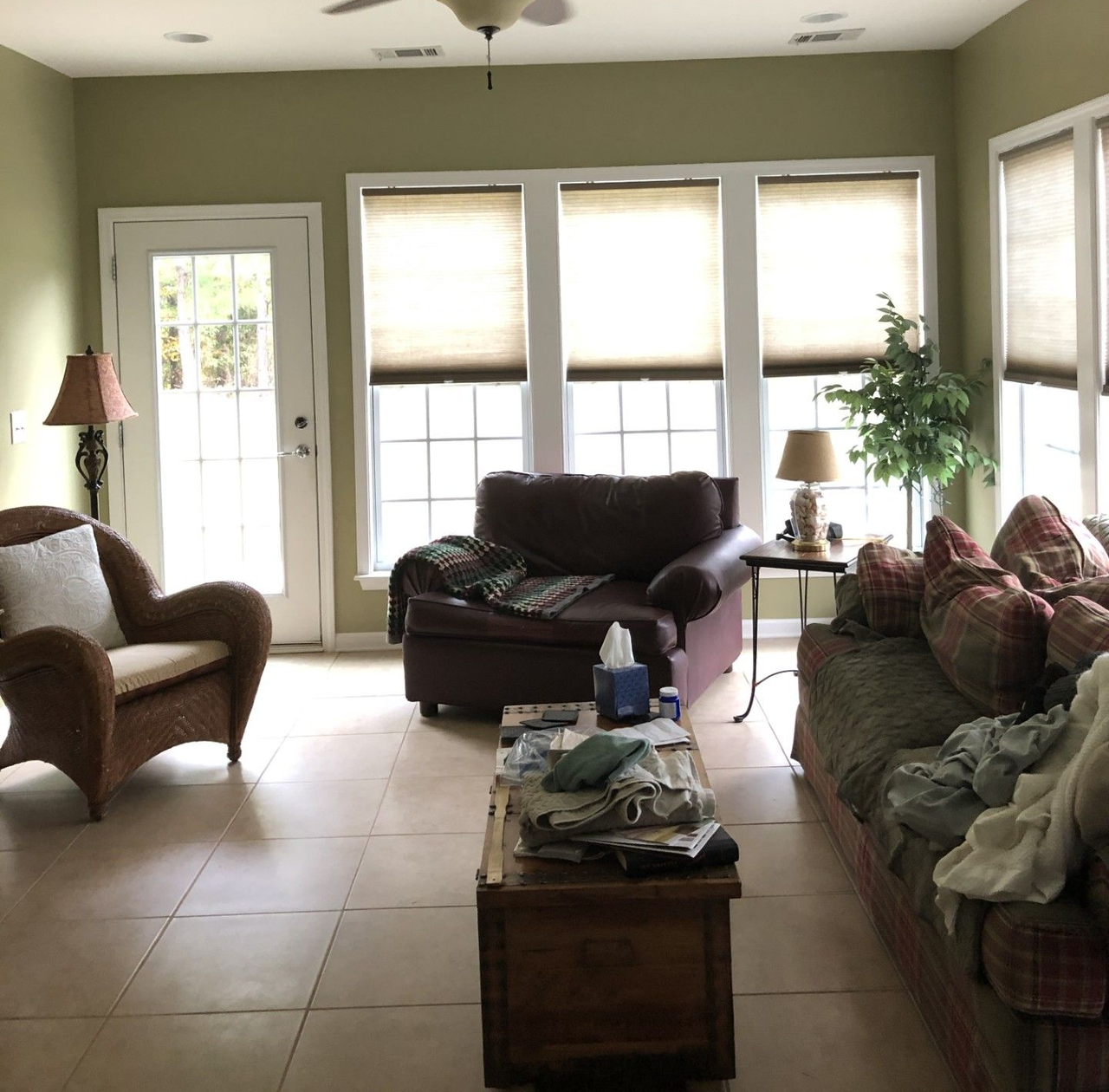 Living room with tile floor, couch, armchair, coffee table, and windows with blinds | Decatur, IL