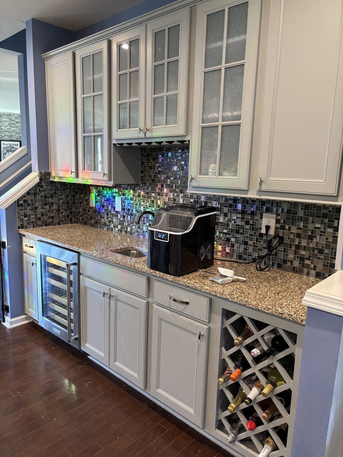 Kitchen wet bar with white cabinets, granite counter, wine rack, and a black countertop appliance | Decatur, IL