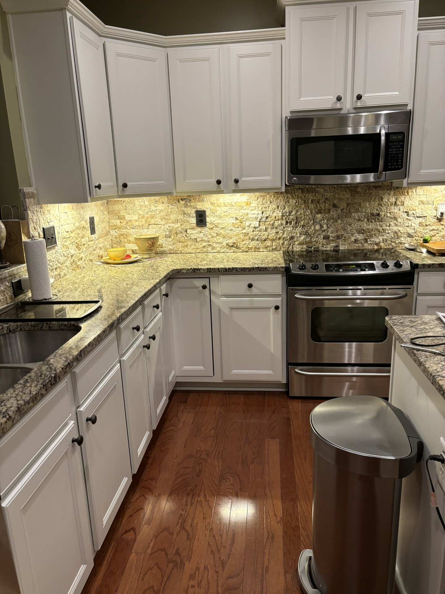 Small kitchen with white cabinets, granite counters, stainless appliances, and wood floors | Decatur, IL