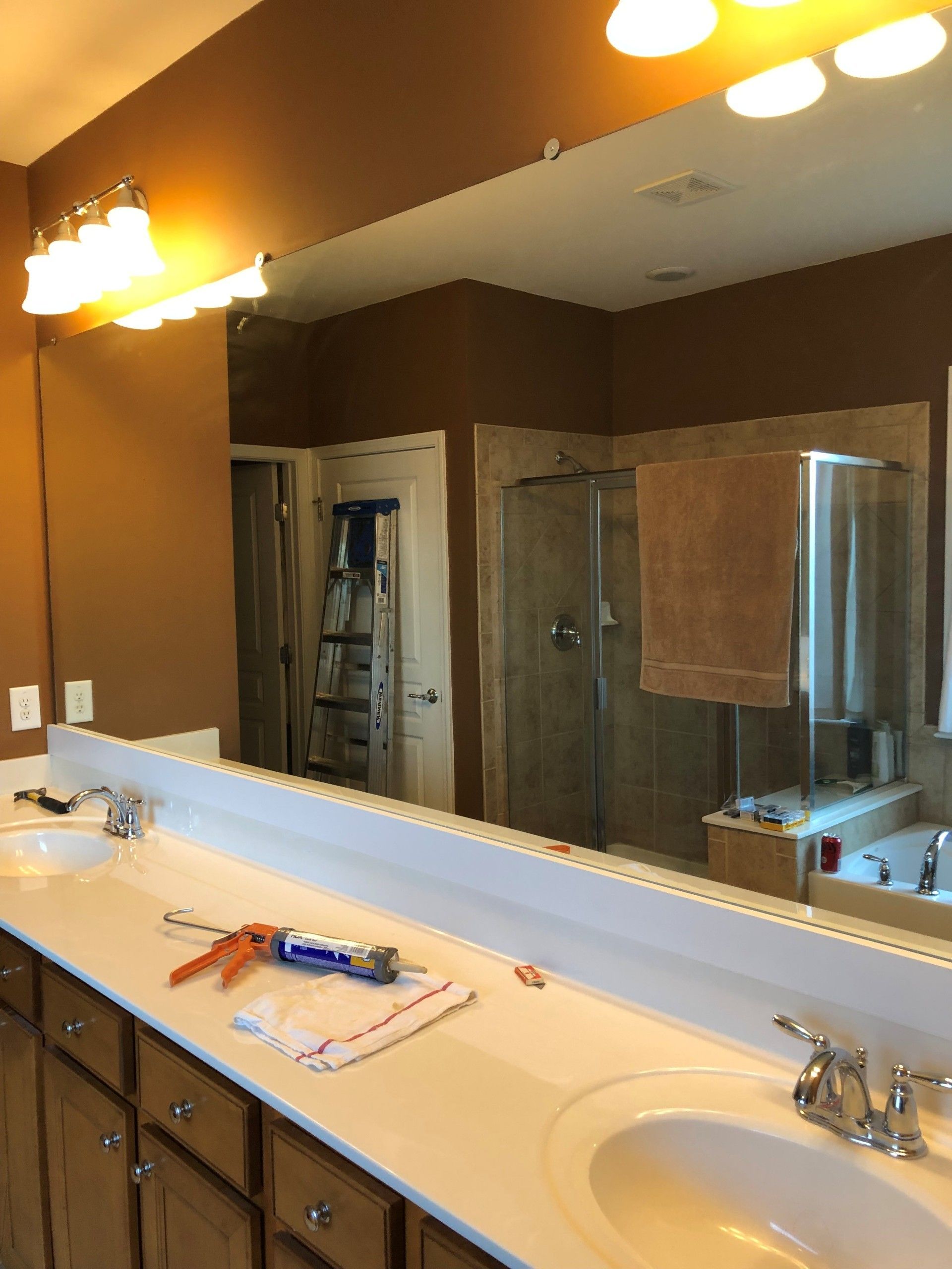 Bathroom vanity with double sinks, large mirror, and a shower visible in the reflection | Decatur, IL