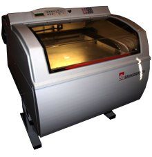 A white machine with a glass door is sitting on a white surface.