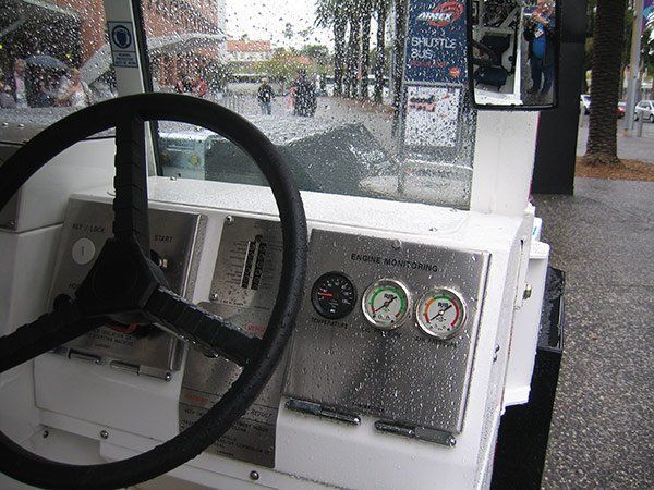 A steering wheel and dashboard with a pepsi sign in the background
