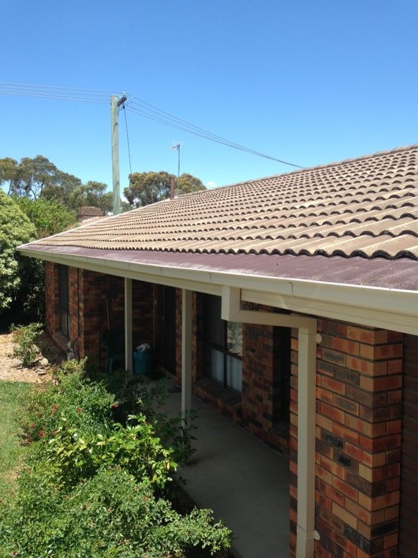 A Close Up Of A Gutter On A Brick house — All Top Roofing In Royalla, NSW